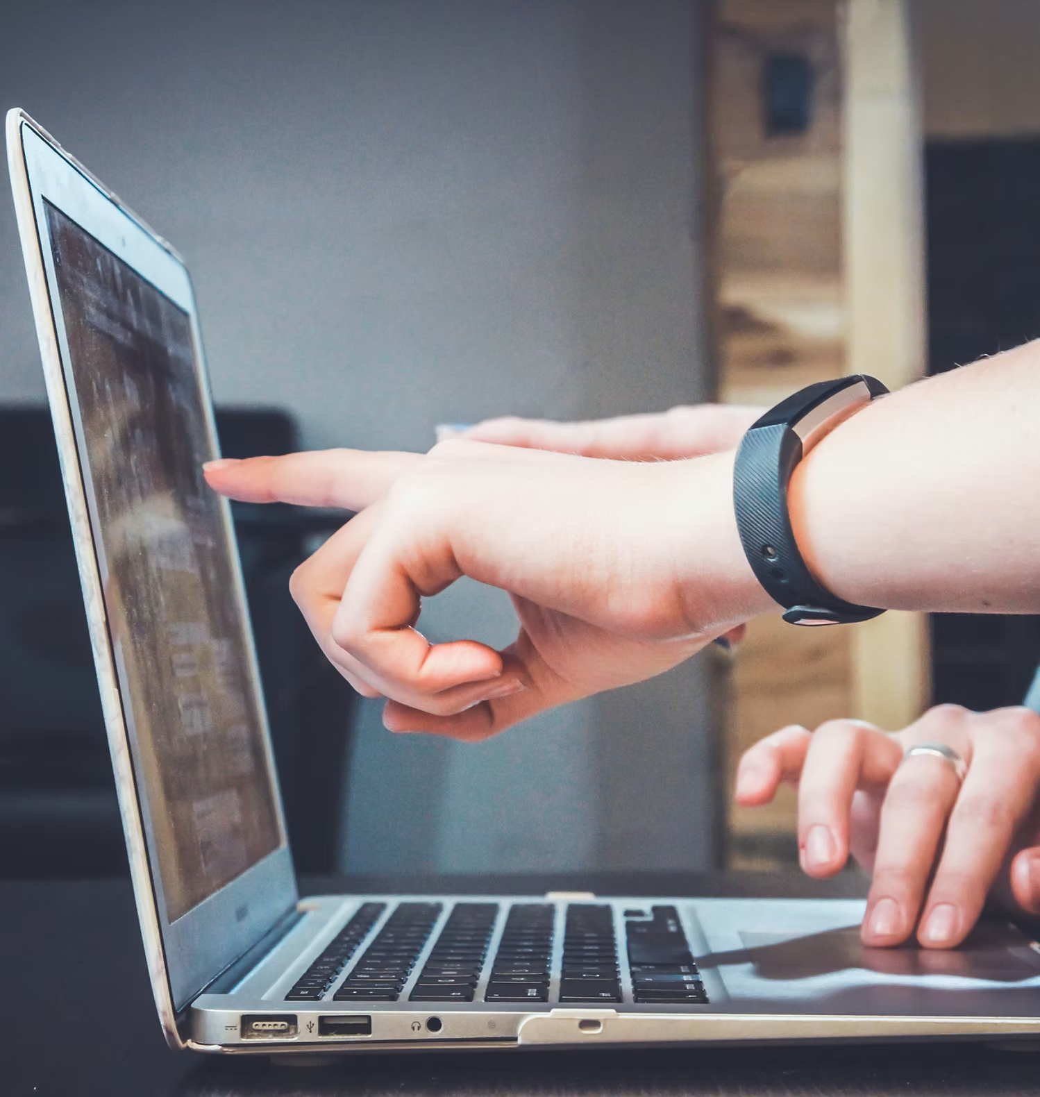 Beratungssituation am Laptop: eine Person zeigt auf den Bildschirm